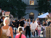 People at a handicraft fair are seen on the Main Market Square in Krakow, Poland, on August 13, 2024. (