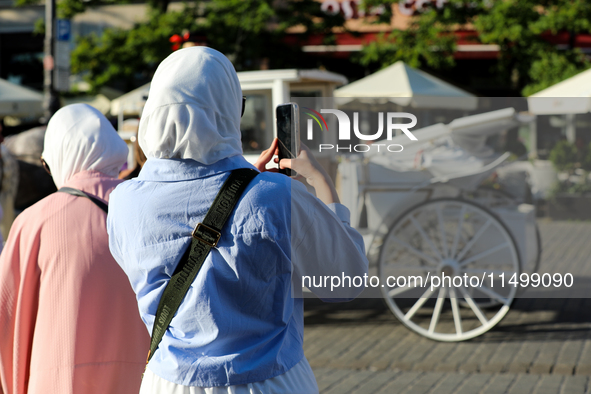 Tourists from the Middle East are seen on the Main Square in Krakow, Poland, on August 13, 2024. 