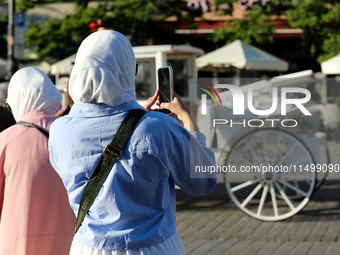 Tourists from the Middle East are seen on the Main Square in Krakow, Poland, on August 13, 2024. (