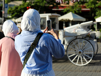 Tourists from the Middle East are seen on the Main Square in Krakow, Poland, on August 13, 2024. (