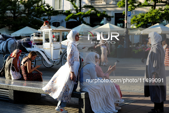 Tourists from the Middle East are seen on the Main Square in Krakow, Poland, on August 13, 2024. 