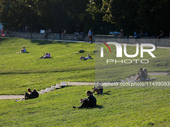 People spend their free time on the boulevards along the Vistula River in Krakow, Poland, on August 13, 2024. (