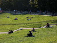 People spend their free time on the boulevards along the Vistula River in Krakow, Poland, on August 13, 2024. (