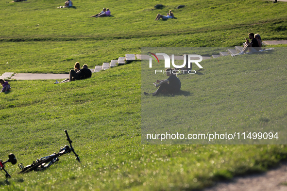 People spend their free time on the boulevards along the Vistula River in Krakow, Poland, on August 13, 2024. 