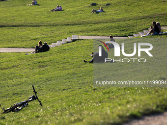 People spend their free time on the boulevards along the Vistula River in Krakow, Poland, on August 13, 2024. (