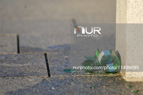 A broken glass beer bottle is seen on the street in Krakow, Poland, on August 13, 2024. 