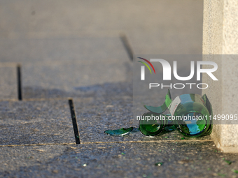 A broken glass beer bottle is seen on the street in Krakow, Poland, on August 13, 2024. (