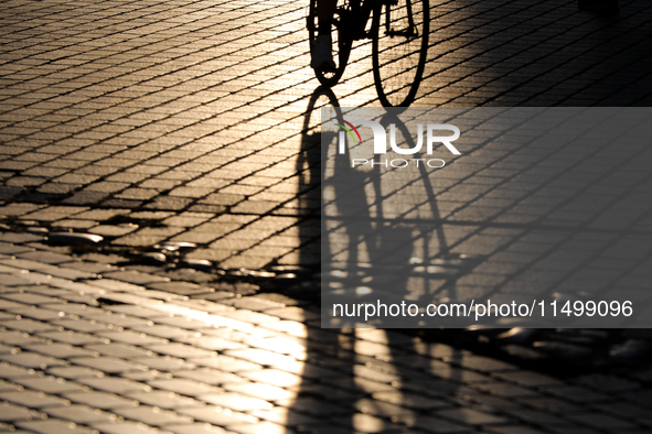 People during sunset are seen on the Main Square in Krakow, Poland, on August 13, 2024. 