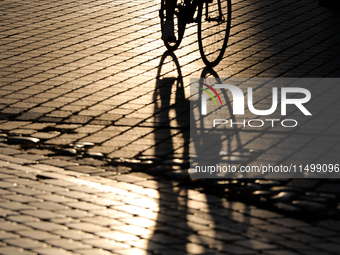 People during sunset are seen on the Main Square in Krakow, Poland, on August 13, 2024. (