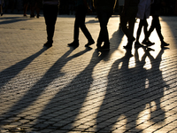 People during sunset are seen on the Main Square in Krakow, Poland, on August 13, 2024. (