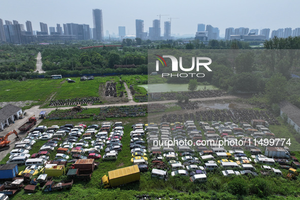 An aerial photo taken on August 22, 2024, shows a large number of cars and motorcycles waiting to be dismantled at a scrap point for discard...