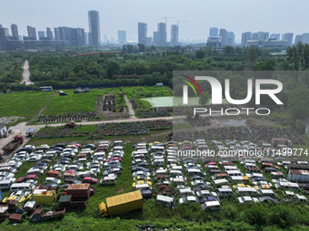 An aerial photo taken on August 22, 2024, shows a large number of cars and motorcycles waiting to be dismantled at a scrap point for discard...