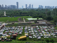 An aerial photo taken on August 22, 2024, shows a large number of cars and motorcycles waiting to be dismantled at a scrap point for discard...