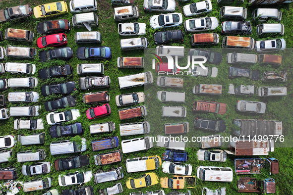 An aerial photo taken on August 22, 2024, shows a large number of cars and motorcycles waiting to be dismantled at a scrap point for discard...