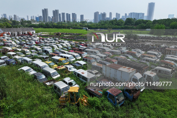 An aerial photo taken on August 22, 2024, shows a large number of cars and motorcycles waiting to be dismantled at a scrap point for discard...