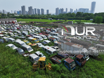 An aerial photo taken on August 22, 2024, shows a large number of cars and motorcycles waiting to be dismantled at a scrap point for discard...