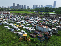 An aerial photo taken on August 22, 2024, shows a large number of cars and motorcycles waiting to be dismantled at a scrap point for discard...