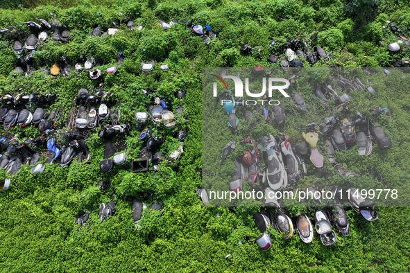 An aerial photo taken on August 22, 2024, shows a large number of cars and motorcycles waiting to be dismantled at a scrap point for discard...