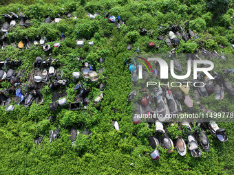 An aerial photo taken on August 22, 2024, shows a large number of cars and motorcycles waiting to be dismantled at a scrap point for discard...