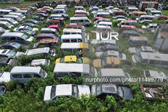 An aerial photo taken on August 22, 2024, shows a large number of cars and motorcycles waiting to be dismantled at a scrap point for discard...