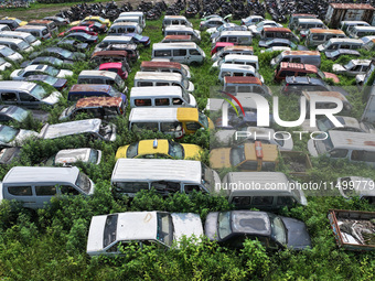 An aerial photo taken on August 22, 2024, shows a large number of cars and motorcycles waiting to be dismantled at a scrap point for discard...