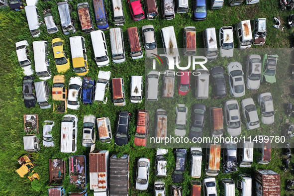 An aerial photo taken on August 22, 2024, shows a large number of cars and motorcycles waiting to be dismantled at a scrap point for discard...