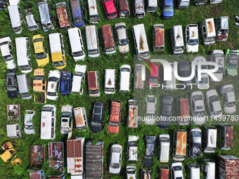 An aerial photo taken on August 22, 2024, shows a large number of cars and motorcycles waiting to be dismantled at a scrap point for discard...