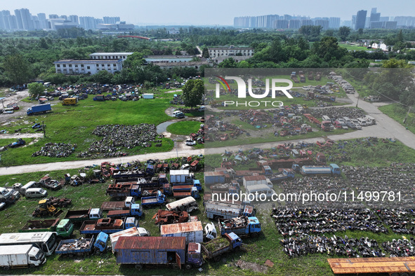 An aerial photo taken on August 22, 2024, shows a large number of cars and motorcycles waiting to be dismantled at a scrap point for discard...