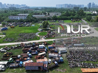 An aerial photo taken on August 22, 2024, shows a large number of cars and motorcycles waiting to be dismantled at a scrap point for discard...