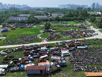 An aerial photo taken on August 22, 2024, shows a large number of cars and motorcycles waiting to be dismantled at a scrap point for discard...