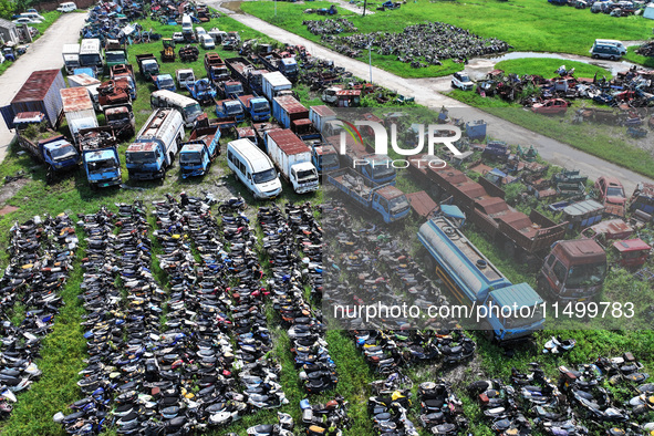 An aerial photo taken on August 22, 2024, shows a large number of cars and motorcycles waiting to be dismantled at a scrap point for discard...