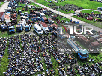 An aerial photo taken on August 22, 2024, shows a large number of cars and motorcycles waiting to be dismantled at a scrap point for discard...