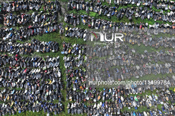 An aerial photo taken on August 22, 2024, shows a large number of cars and motorcycles waiting to be dismantled at a scrap point for discard...