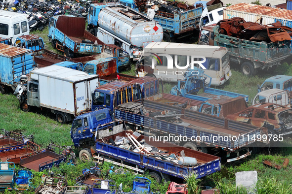 An aerial photo taken on August 22, 2024, shows a large number of cars and motorcycles waiting to be dismantled at a scrap point for discard...