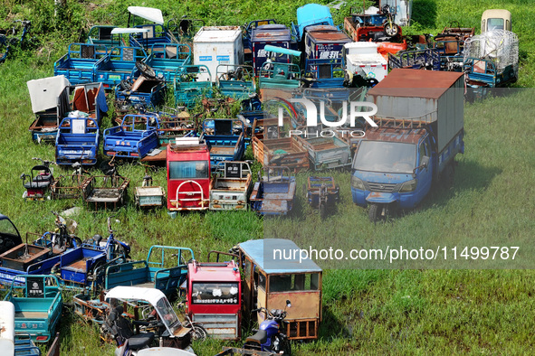 An aerial photo taken on August 22, 2024, shows a large number of cars and motorcycles waiting to be dismantled at a scrap point for discard...