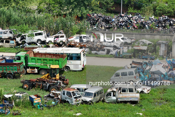 An aerial photo taken on August 22, 2024, shows a large number of cars and motorcycles waiting to be dismantled at a scrap point for discard...