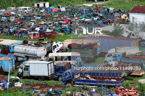 An aerial photo taken on August 22, 2024, shows a large number of cars and motorcycles waiting to be dismantled at a scrap point for discard...