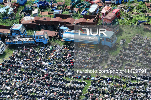 An aerial photo taken on August 22, 2024, shows a large number of cars and motorcycles waiting to be dismantled at a scrap point for discard...