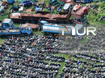 An aerial photo taken on August 22, 2024, shows a large number of cars and motorcycles waiting to be dismantled at a scrap point for discard...