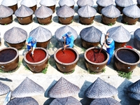 Workers use a wooden rake to turn sauces at the old soy sauce natural drying sauce shop in Yanhe Village, Rucheng Street, Rugao city, East C...