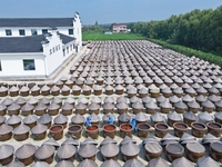 Workers use a wooden rake to turn sauces at the old soy sauce natural drying sauce shop in Yanhe Village, Rucheng Street, Rugao city, East C...