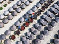 Workers use a wooden rake to turn sauces at the old soy sauce natural drying sauce shop in Yanhe Village, Rucheng Street, Rugao city, East C...