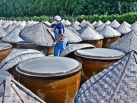 Workers use a wooden rake to turn sauces at the old soy sauce natural drying sauce shop in Yanhe Village, Rucheng Street, Rugao city, East C...