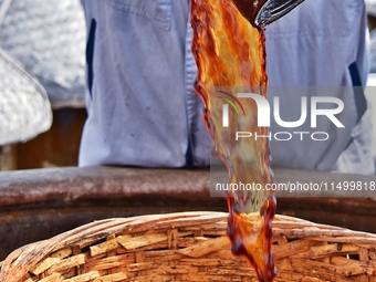 Workers use a wooden rake to turn sauces at the old soy sauce natural drying sauce shop in Yanhe Village, Rucheng Street, Rugao city, East C...