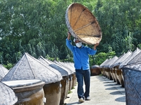 Workers use a wooden rake to turn sauces at the old soy sauce natural drying sauce shop in Yanhe Village, Rucheng Street, Rugao city, East C...