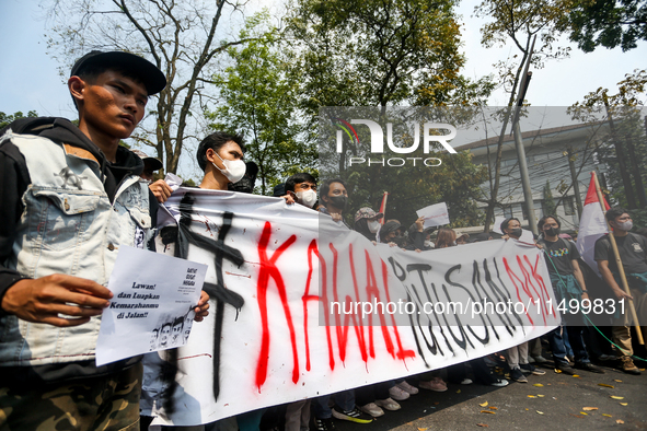 Students hold protest posters during a demonstration to reject the ratification of the Regional Head Election (Pilkada) Bill in front of the...