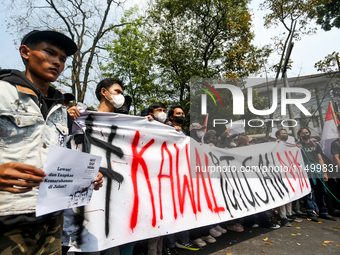 Students hold protest posters during a demonstration to reject the ratification of the Regional Head Election (Pilkada) Bill in front of the...