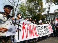 Students hold protest posters during a demonstration to reject the ratification of the Regional Head Election (Pilkada) Bill in front of the...