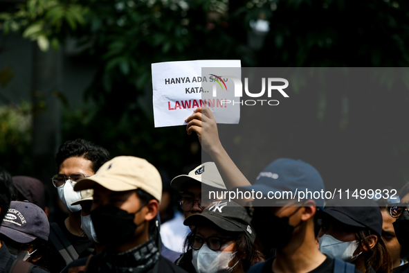 Students hold protest posters during a demonstration to reject the ratification of the Regional Head Election (Pilkada) Bill in front of the...