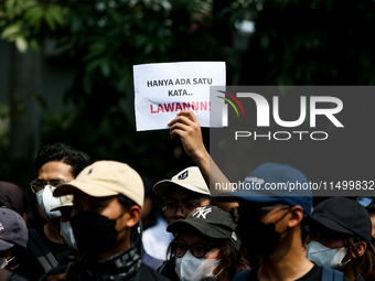 Students hold protest posters during a demonstration to reject the ratification of the Regional Head Election (Pilkada) Bill in front of the...